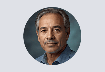 Head and shoulders photo of gray-haired male freelancer wearing a light blue shirt