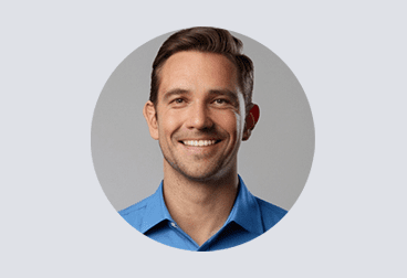 Head and shoulders photo of smiling male freelancer with brown hair wearing a blue shirt