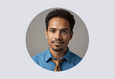 Head and shoulders photo of male freelancer with black hair wearing a light blue shirt and golden tie with subtle pattern