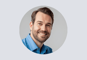 Head and shoulders photo of male freelancer wearing a light blue shirt and smiling